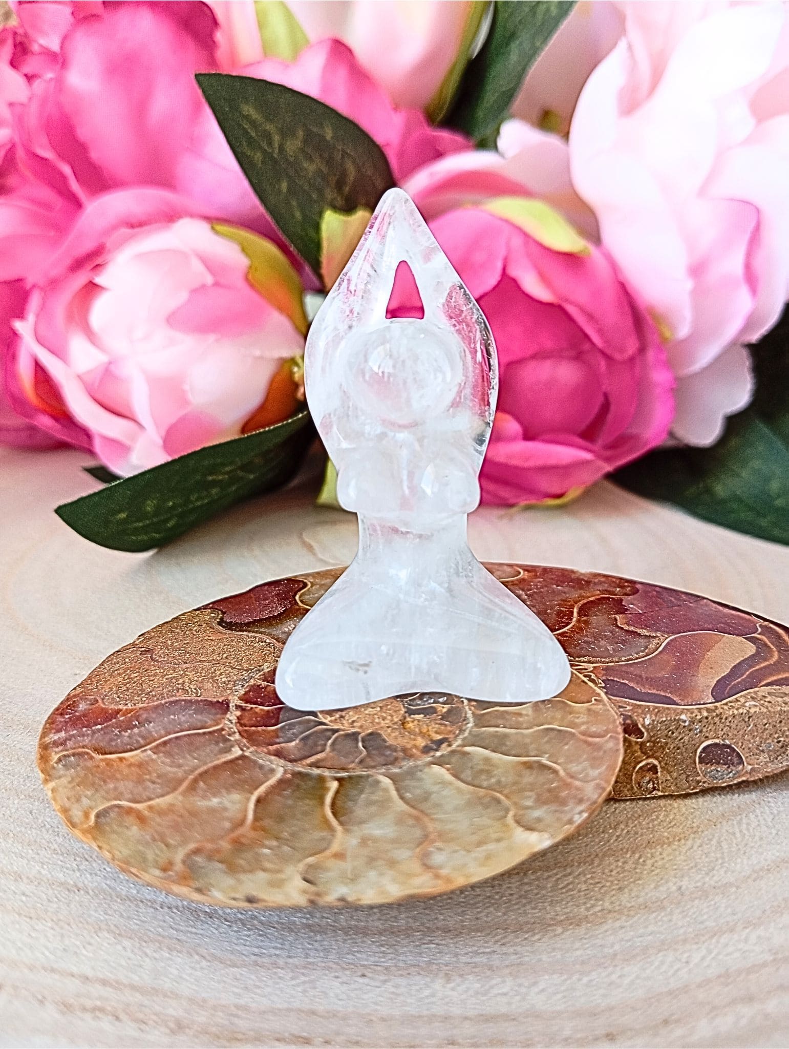 statuette en cristal de roche sur fossile dammonite