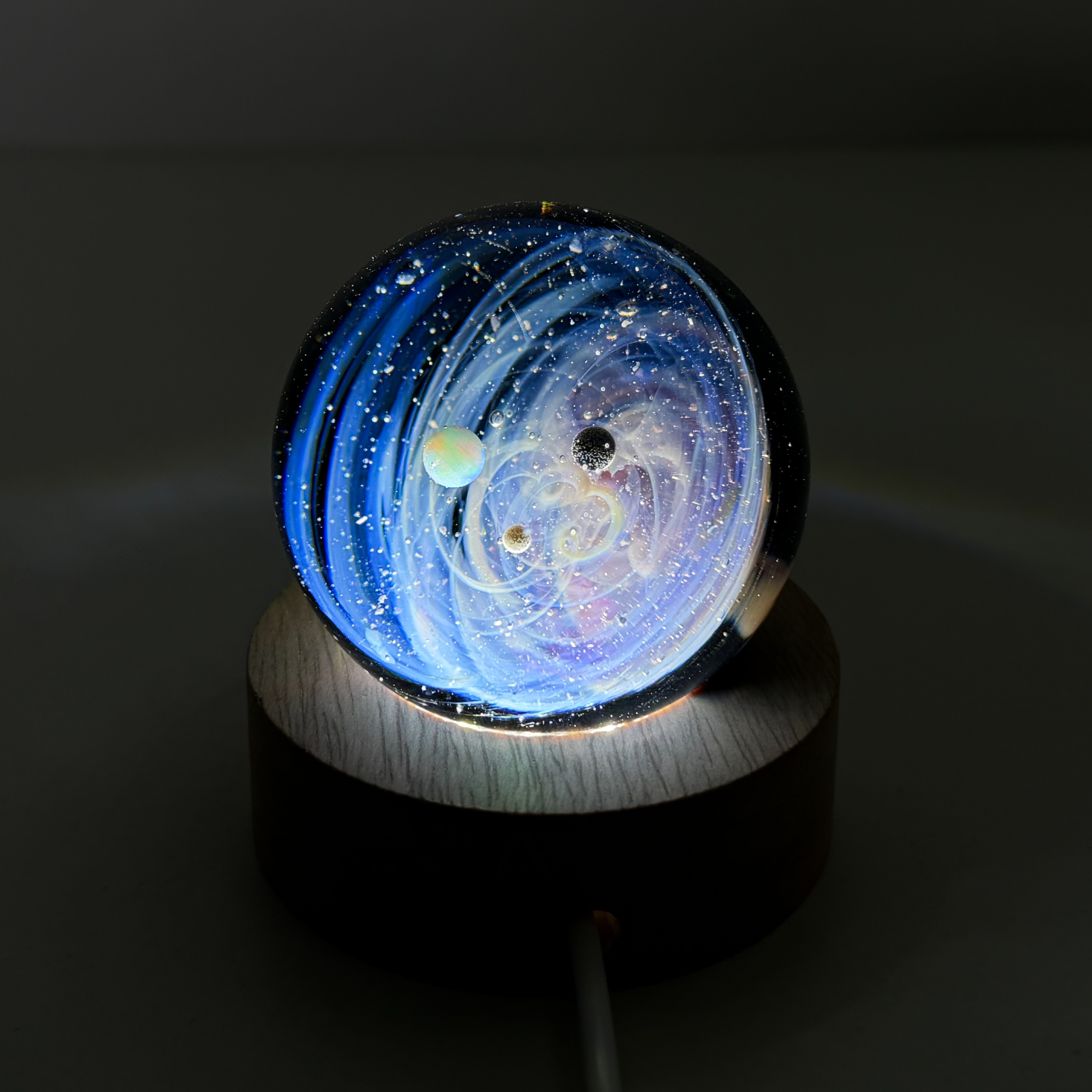 Sphère de verre système solaire sur socle lumineux