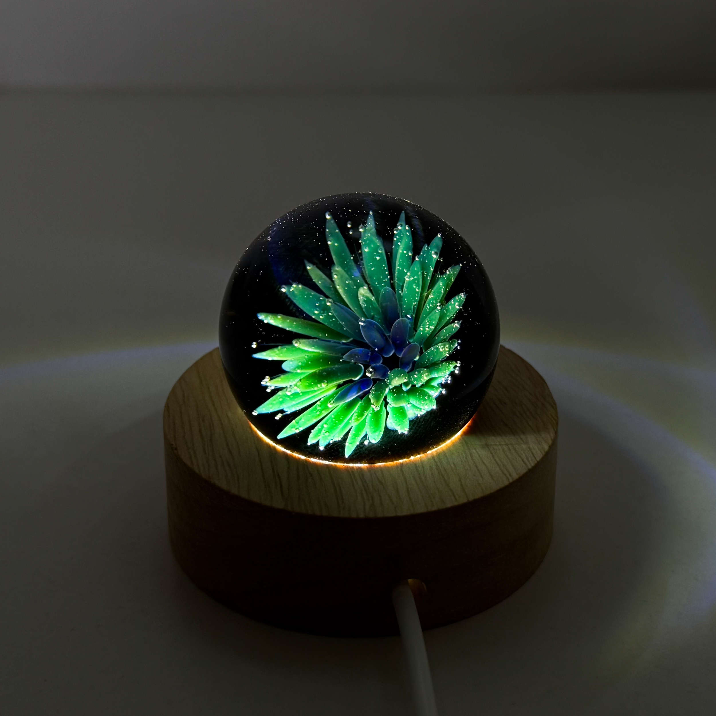 Sphère de verre fleur sur support lumineux