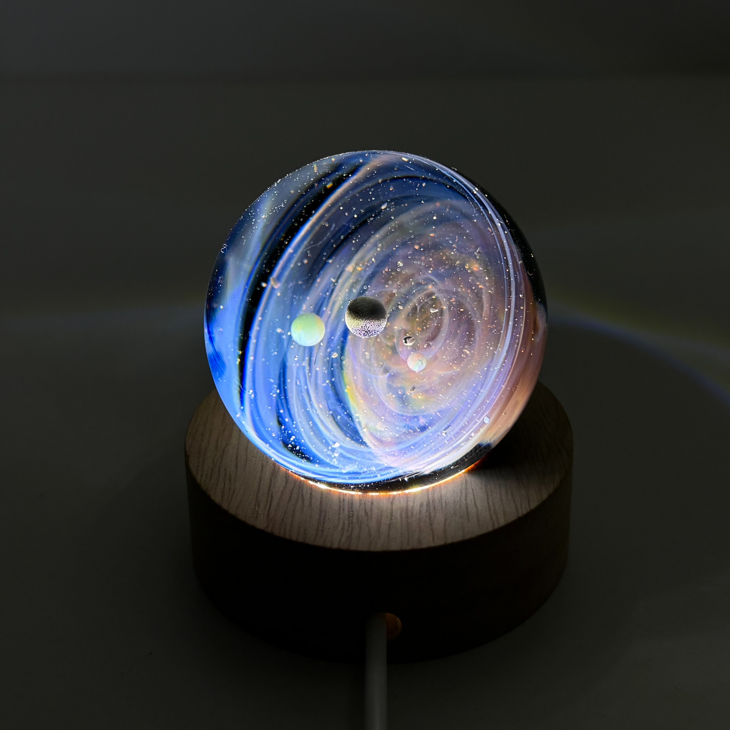 Sphère de verre système solaire sur socle lumineux