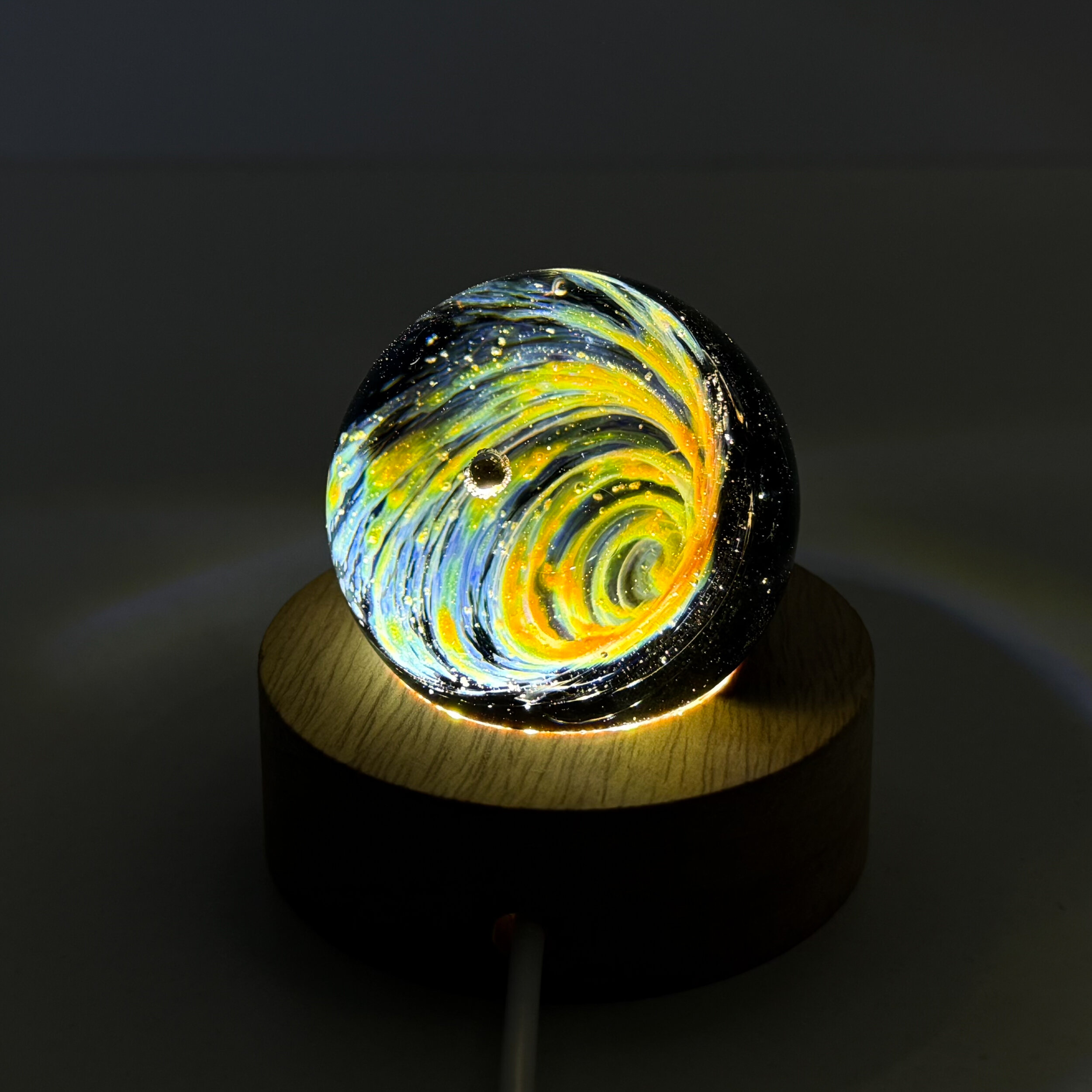 Sphère galaxie et pépite d\'or sur socle lumineux