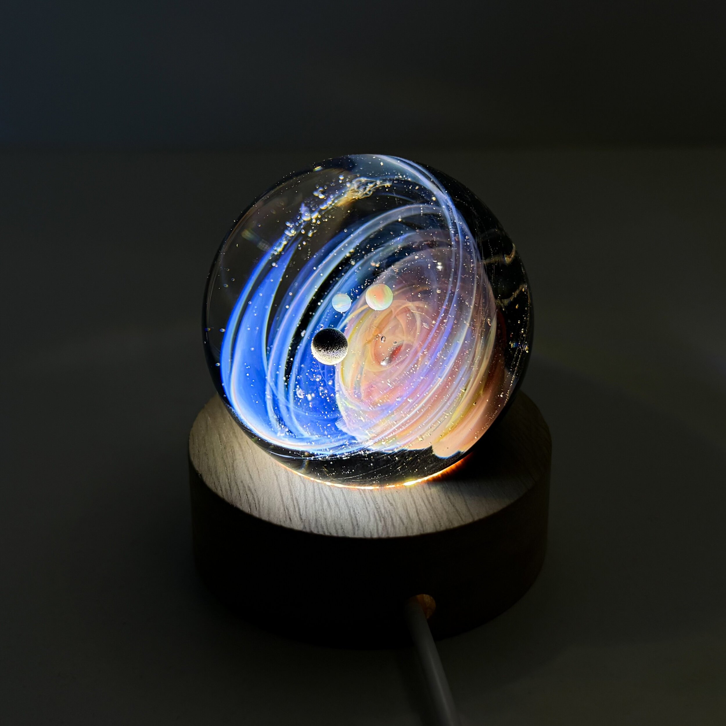 Sphère de verre système solaire sur socle lumineux