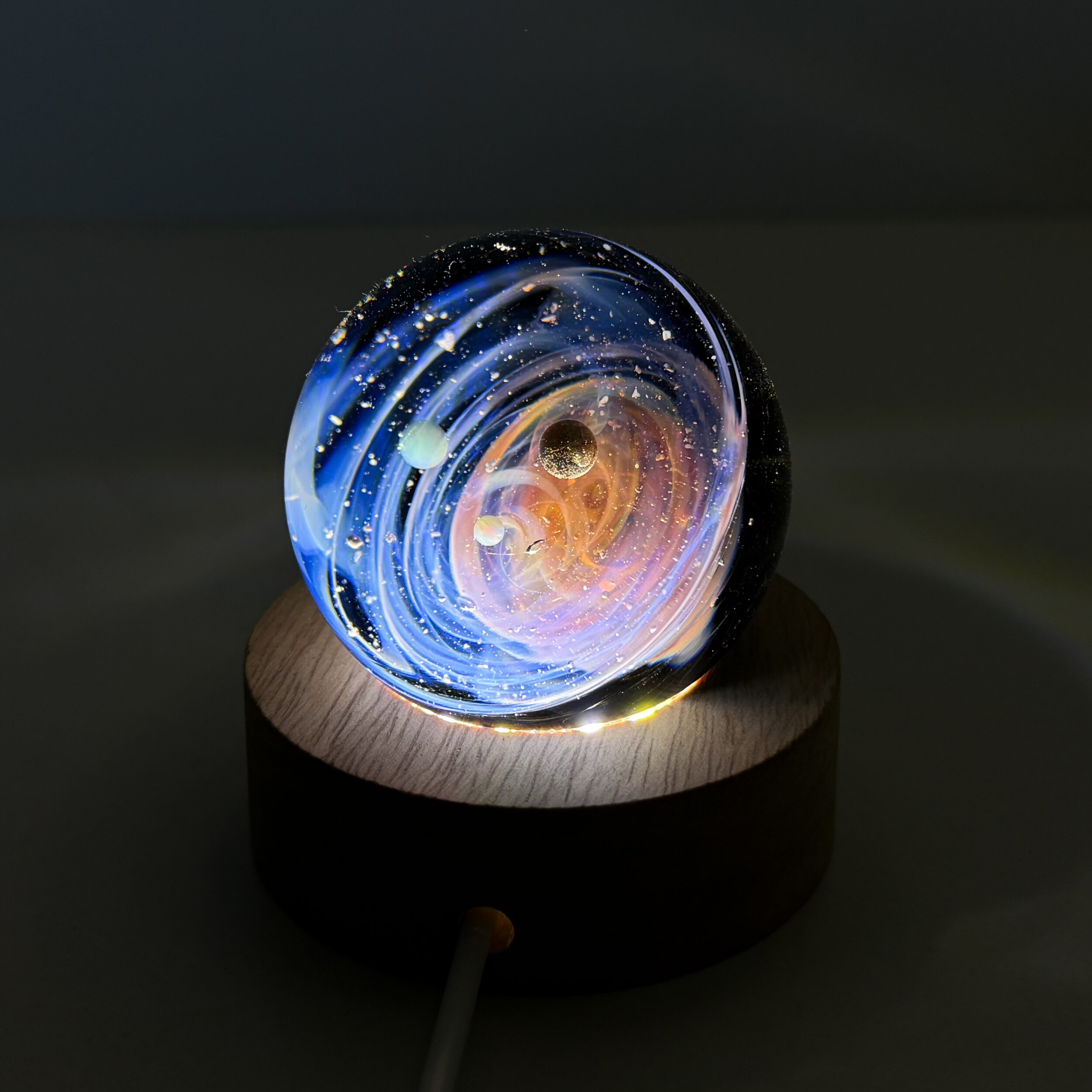 Sphère de verre système solaire sur socle lumineux