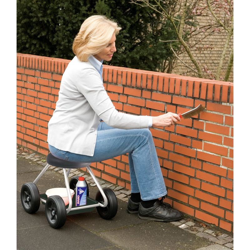 une-femme-nettoie-un-mur-assise-sur-un-siege-de-jardin-a-roulettte