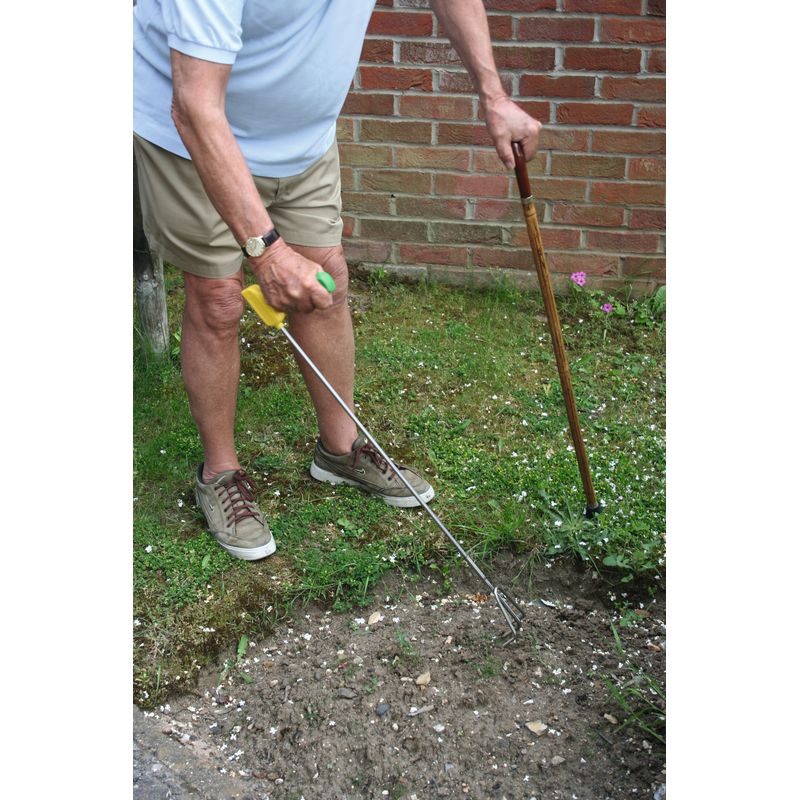 un-homme-jardine-debout-en-s-appuyant-sur-une-canne-de-l-autre-main-il-utilise-une-griffe-de-jardin-a-long-manche
