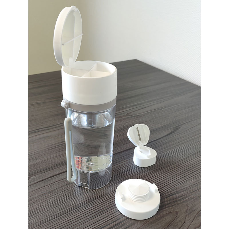 une-gourde-pilulier-coupe-broyeur-comprimé-pose-sur-une-table-avec-accessoires-a-cote