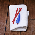 un-manche-multi-usages-bleu-avec-lime-a-ongles-introduite-dedans-pose-avec-3-limes-sur-serviette-blanche-sur-banc-de-sauna