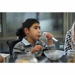 un-enfant-porte-a-sa-bouche-une-cuillere-anti-tremblement-elispoon