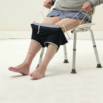 un-homme-assis-sur-une-chaise-enfile-son-slip-avec-enfile-slip-pliable
