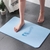 deux-pieds-qui-sortent-de-la-douche-et qui-sont-sur-sortie-bain-antiderapante-en-diatomite