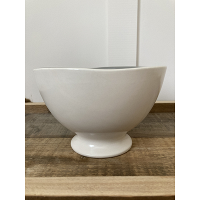 Bol en faïence gris clair avec finition émaillée posé sur une table en bois ambiance chaleureuse