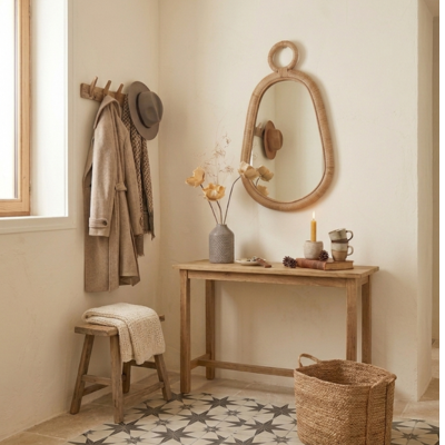 Miroir ovale en rotin naturel accroché au mur
