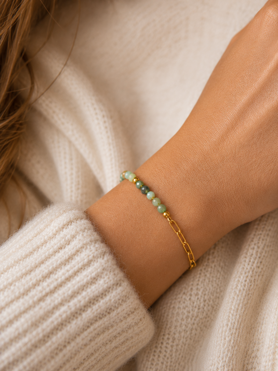 Bracelet vert d’eau et or porté au poignet dans une ambiance cosy chic