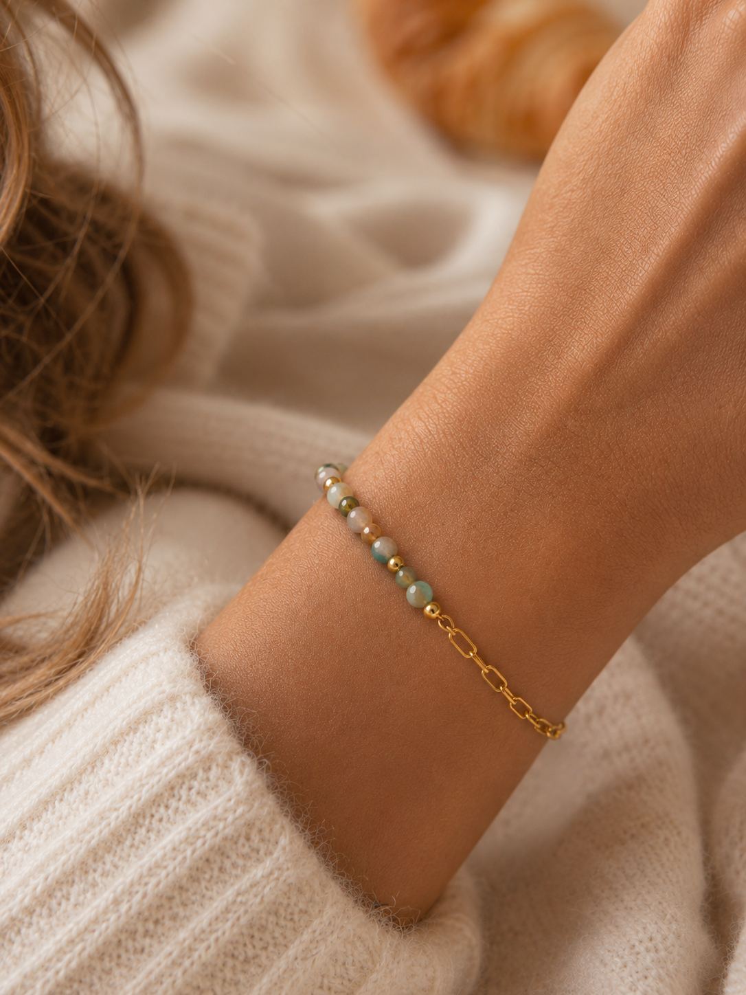 Bracelet Vana multicolore naturel et doré porté avec maille crème cosy