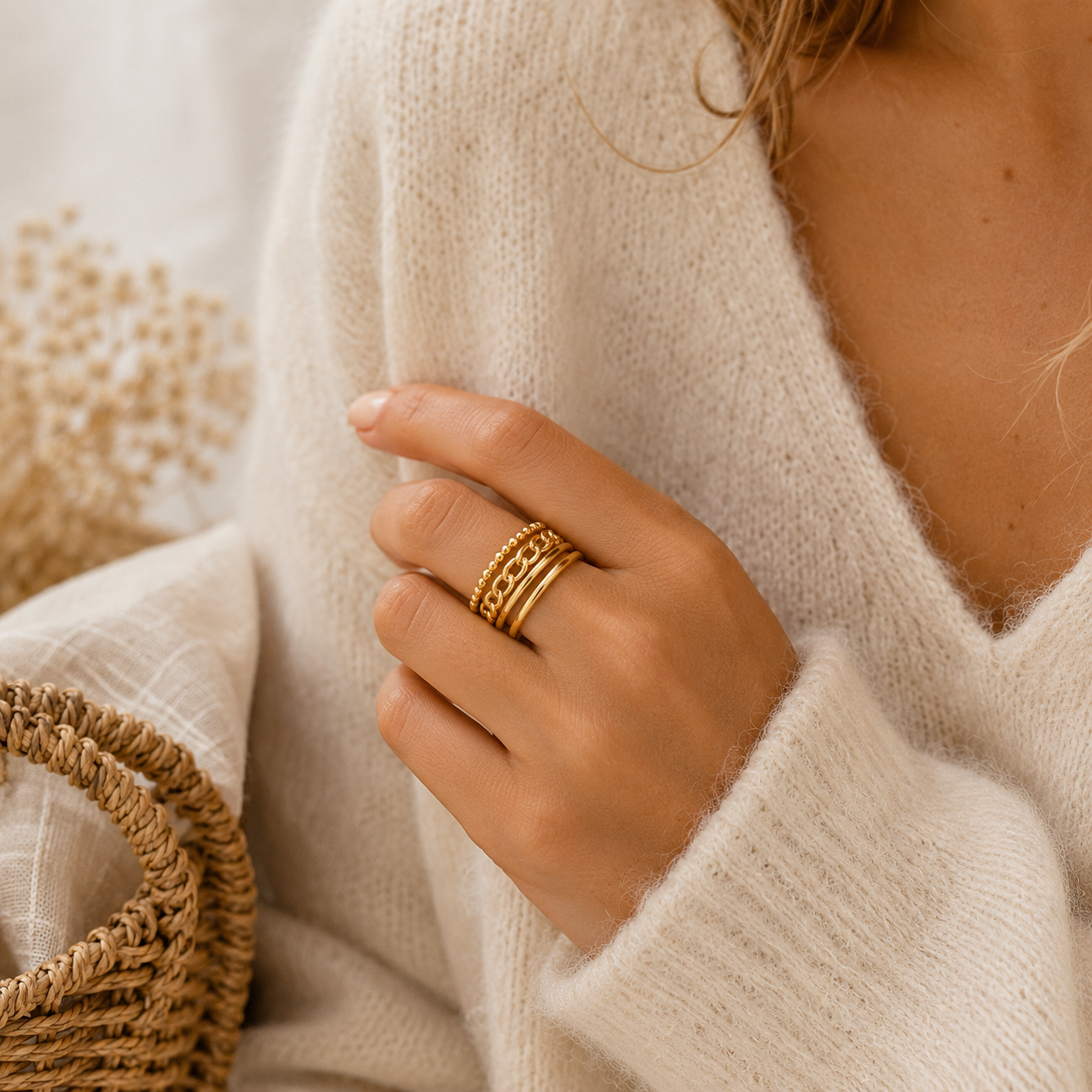 Main portant la bague Ornella dorée avec pull mohair beige dans une ambiance douce et naturelle – bijou femme Bella Cosa