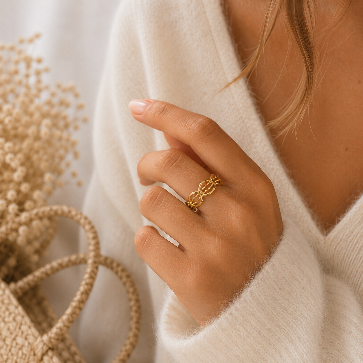 Main portant la bague Olia dorée aux maillons ovales avec pull mohair beige dans une ambiance douce et naturelle – bijou femme Bella Cosa