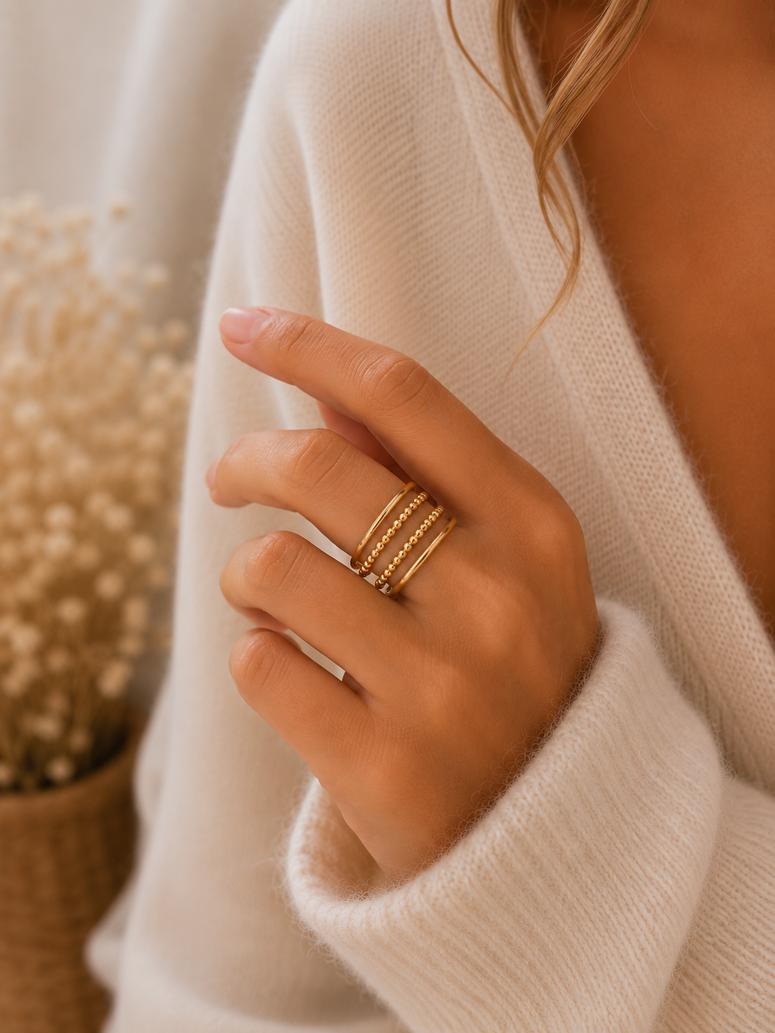 Main portant la bague Orane dorée à quatre anneaux avec pull mohair beige dans une ambiance douce et naturelle – bijou femme Bella Cosa