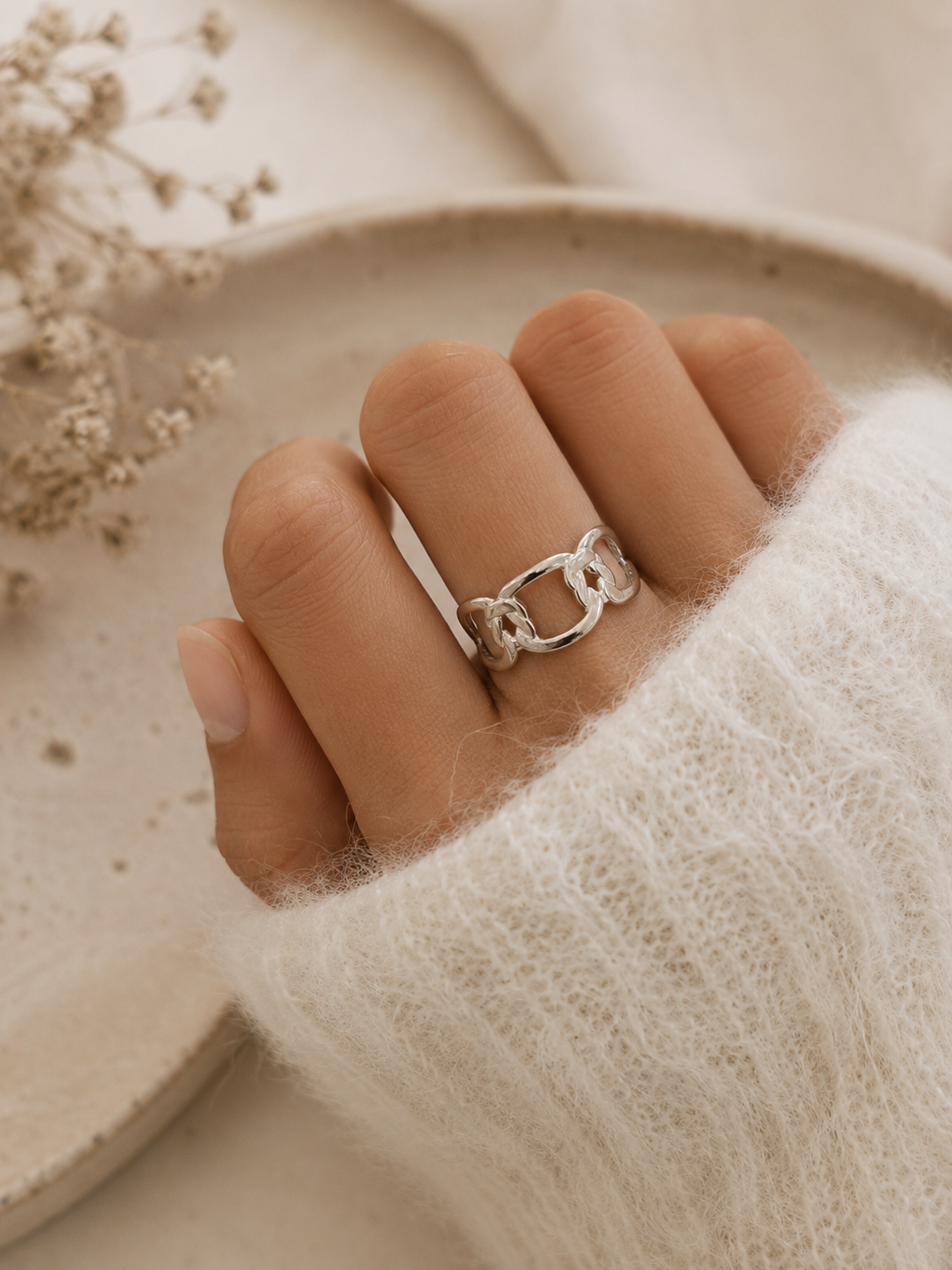 Main portant la bague Pia argentée avec pull mohair crème dans une ambiance cosy et naturelle – bijou femme Bella Cosa