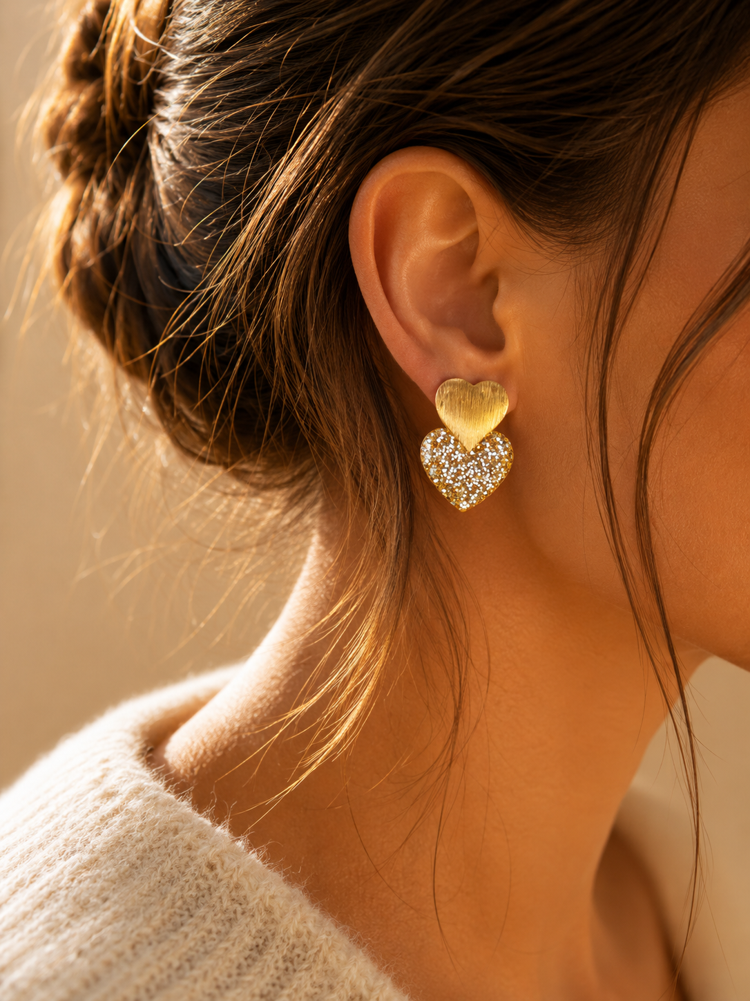 Boucles d’oreilles Caroline dorées en forme de cœur pailleté portées lumière naturelle chaleureuse