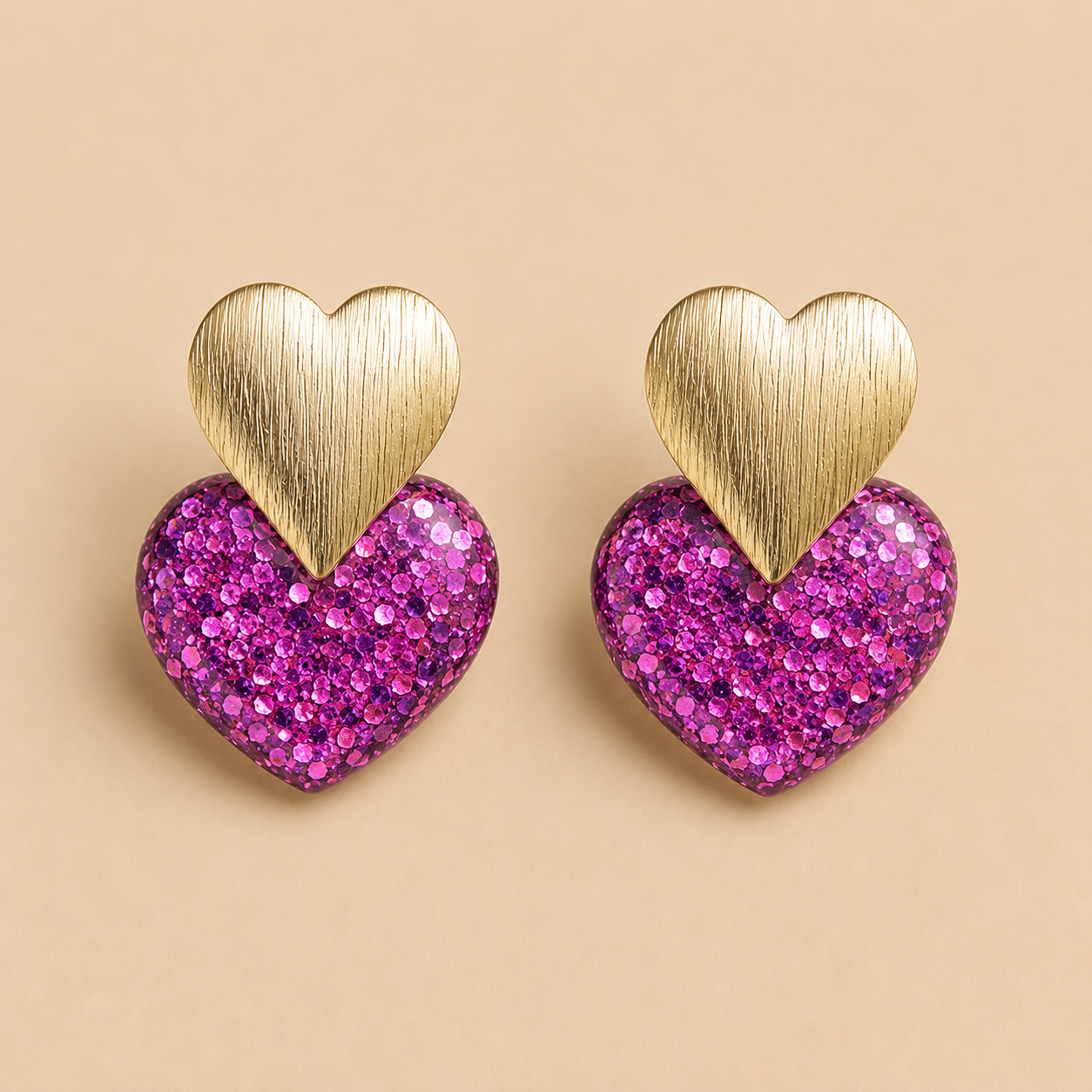 Boucles d’oreilles Caroline violet fuchsia cœur pailleté doré sur fond beige élégant et féminin