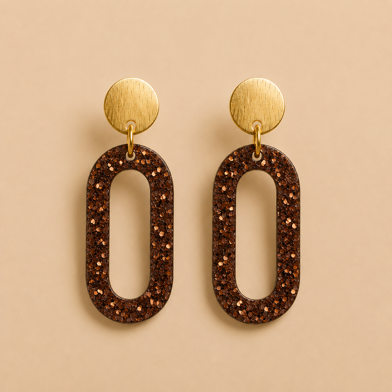 Boucles d’oreilles Clémentine moka en résine pailletée sur fond beige naturel