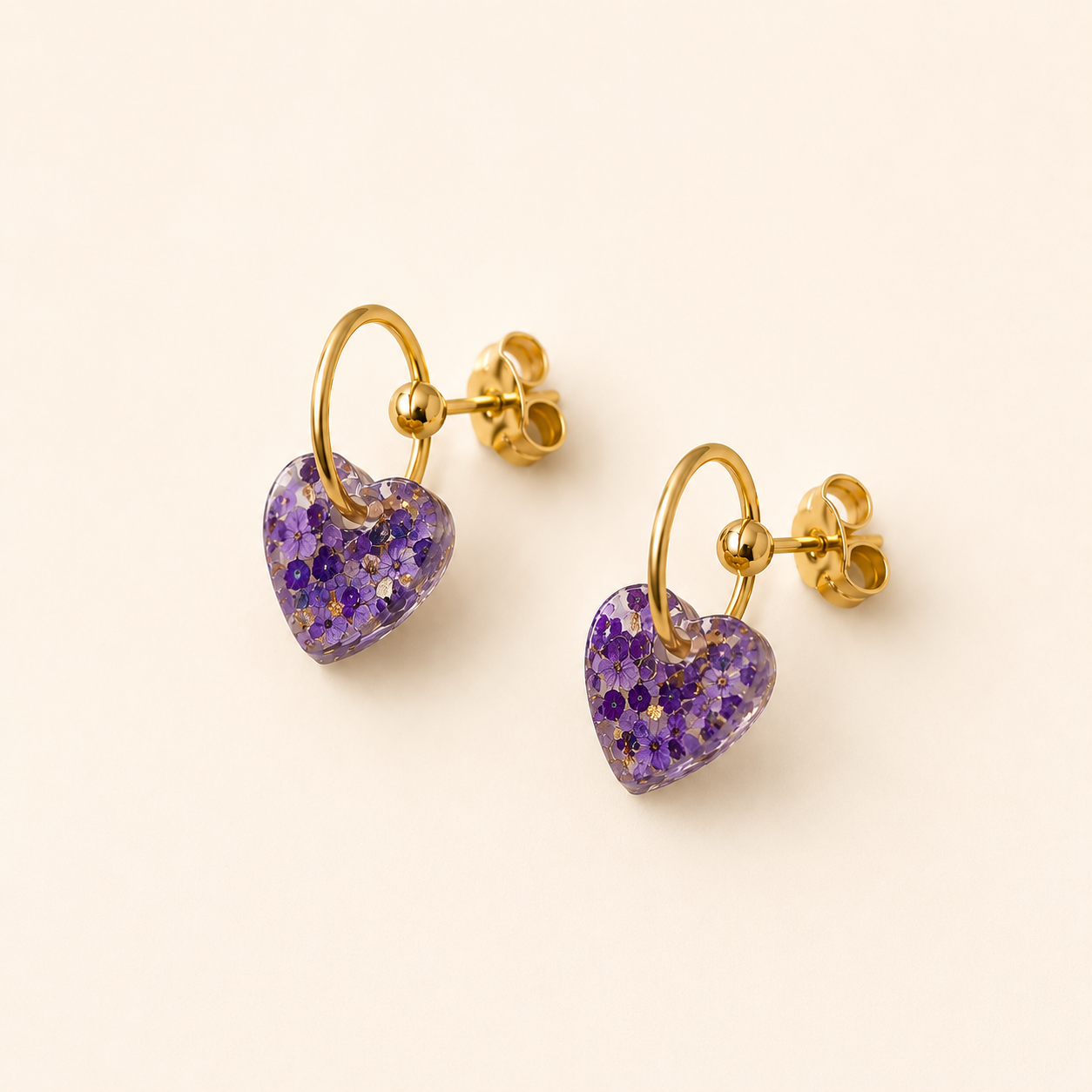 Boucles d’oreilles Cassie violettes avec cœur en résine pailletée et anneau doré sur fond clair minimaliste