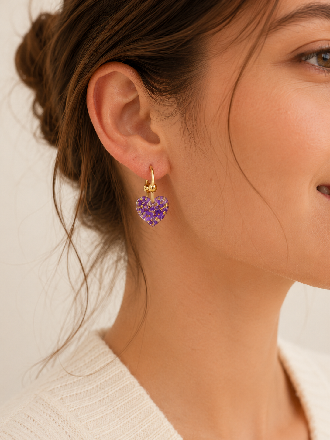 Boucles d’oreilles Cassie violettes en résine portées avec anneau doré et ambiance douce