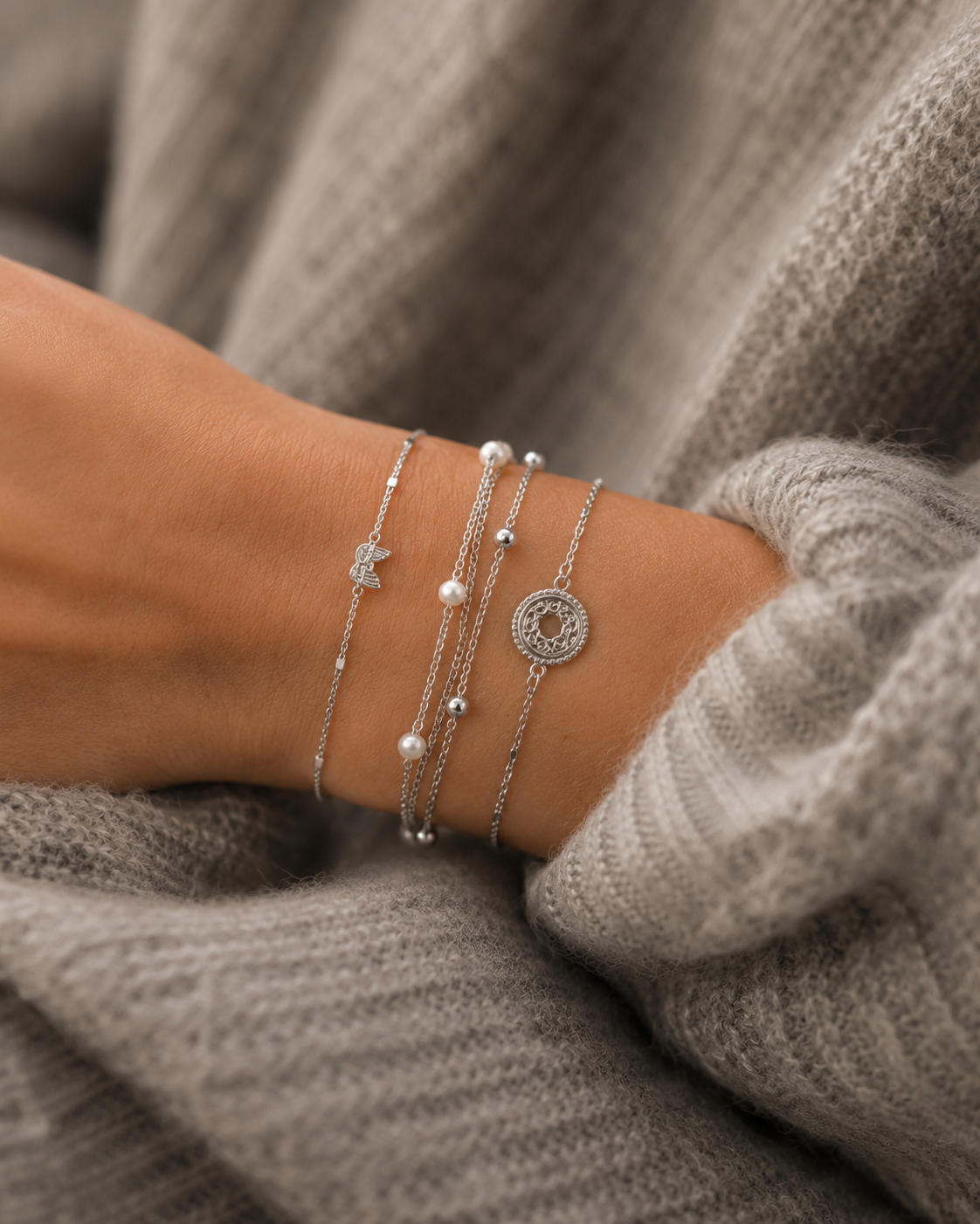 Accumulation de bracelets argentés fins et perlés portés sur poignet féminin – bijoux minimalistes et élégants Bella Cosa