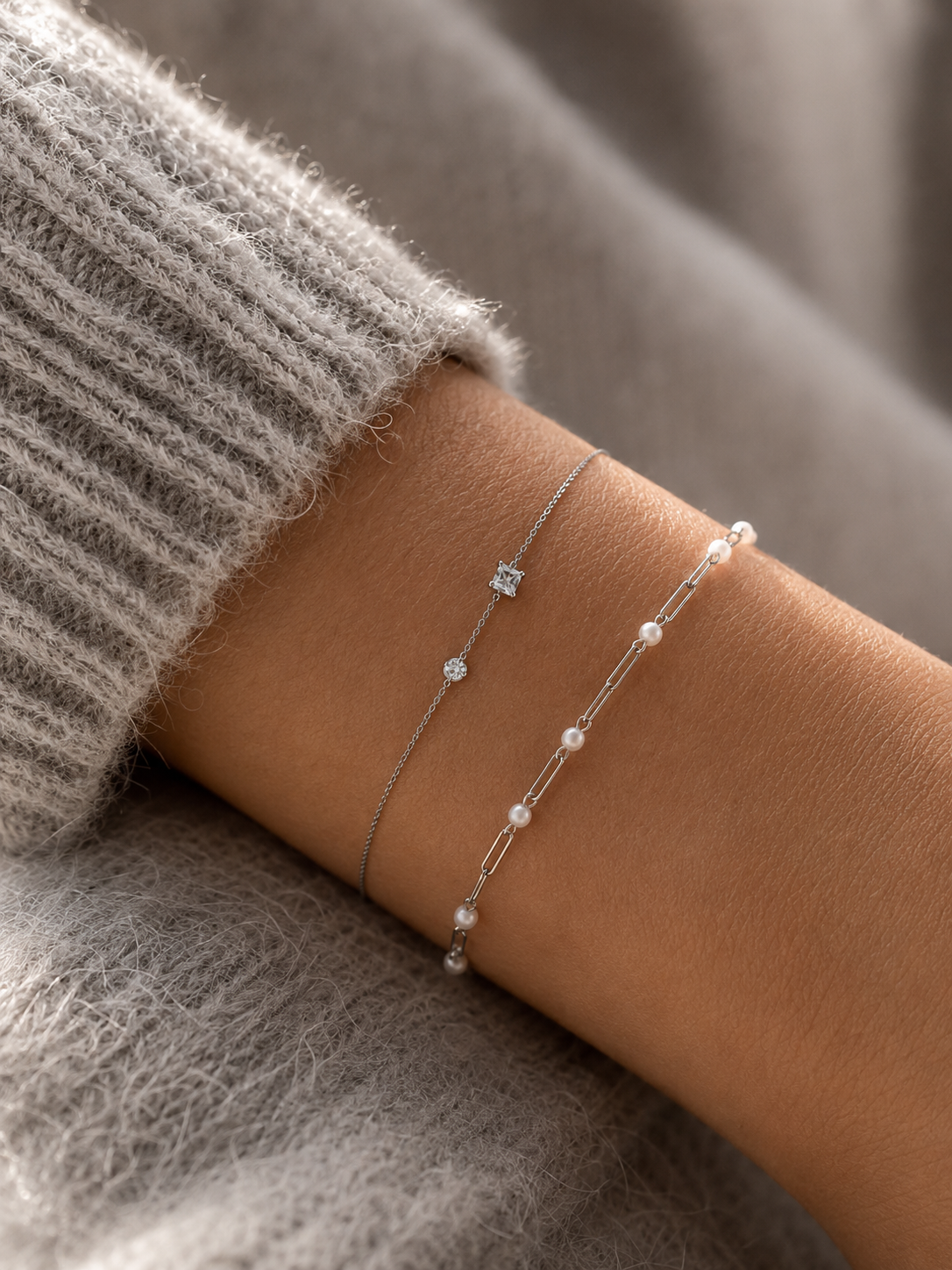 Accumulation de bracelets fins argentés avec perles blanches et pierres délicates portés sur poignet féminin – bijoux minimalistes Bella Cosa