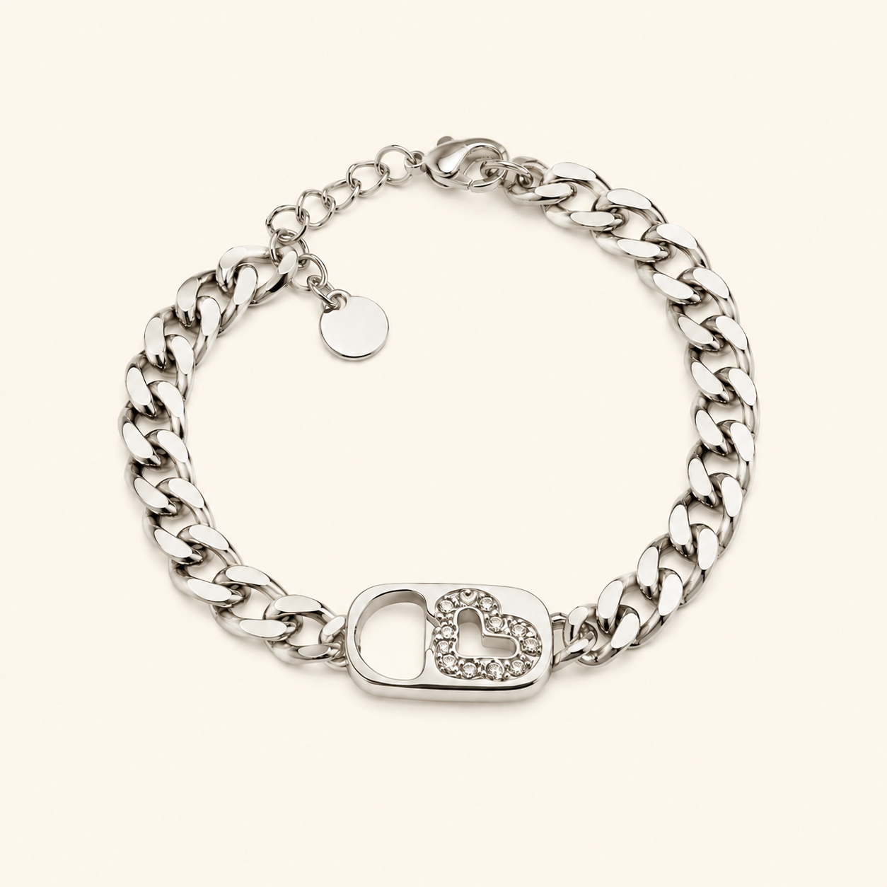 Bracelet Gizem argenté à mailles gourmette avec fermoir cœur serti de zirconiums sur fond beige clair minimaliste