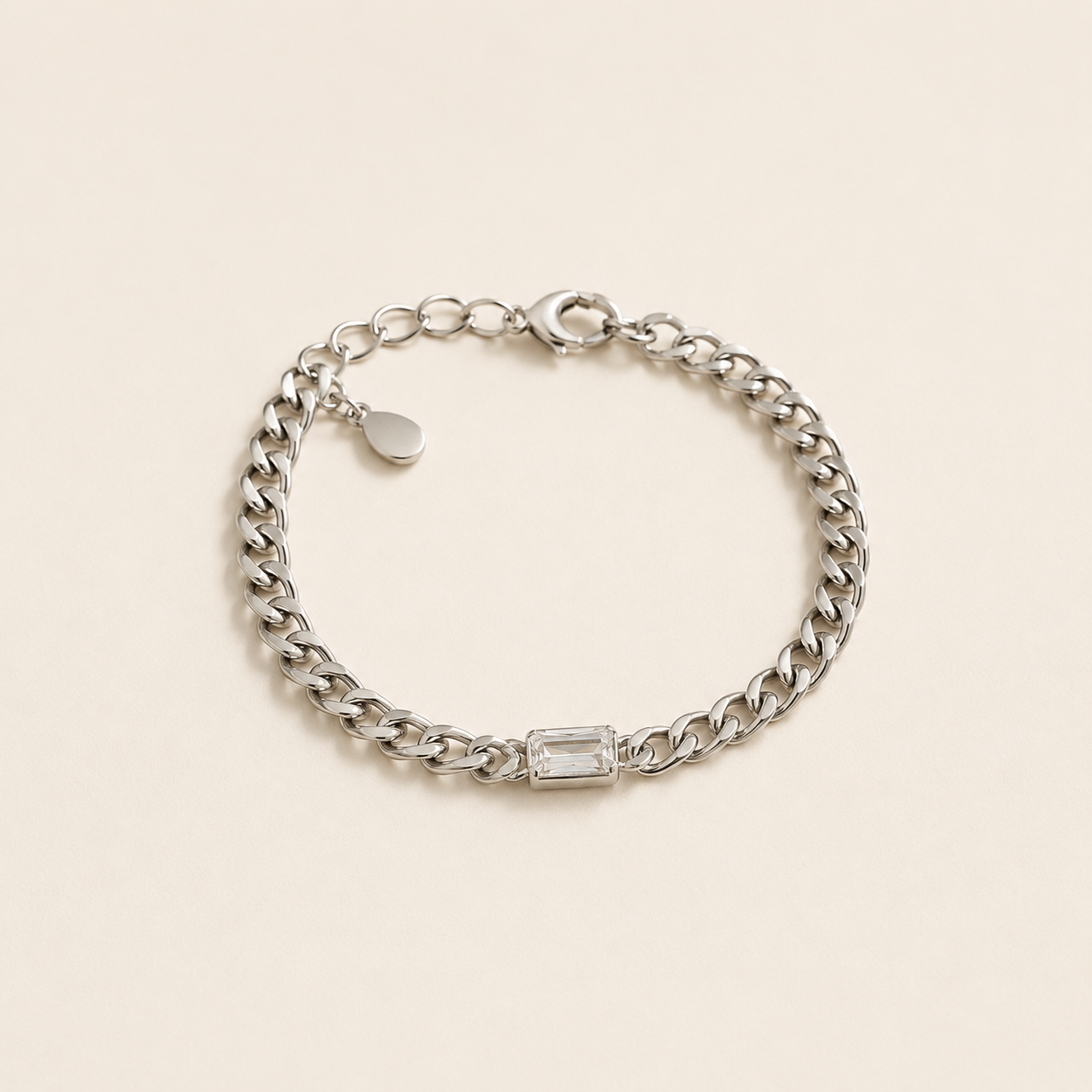 Bracelet Gena argenté style gourmette avec pierre rectangulaire lumineuse sur fond crème minimaliste