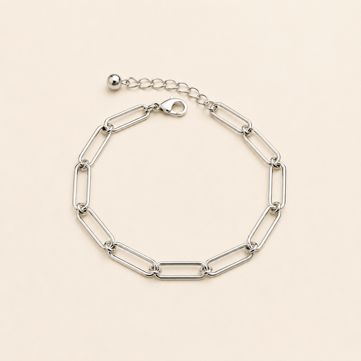 Bracelet Ginnie argenté à maille trombone minimaliste sur fond crème doux et épuré