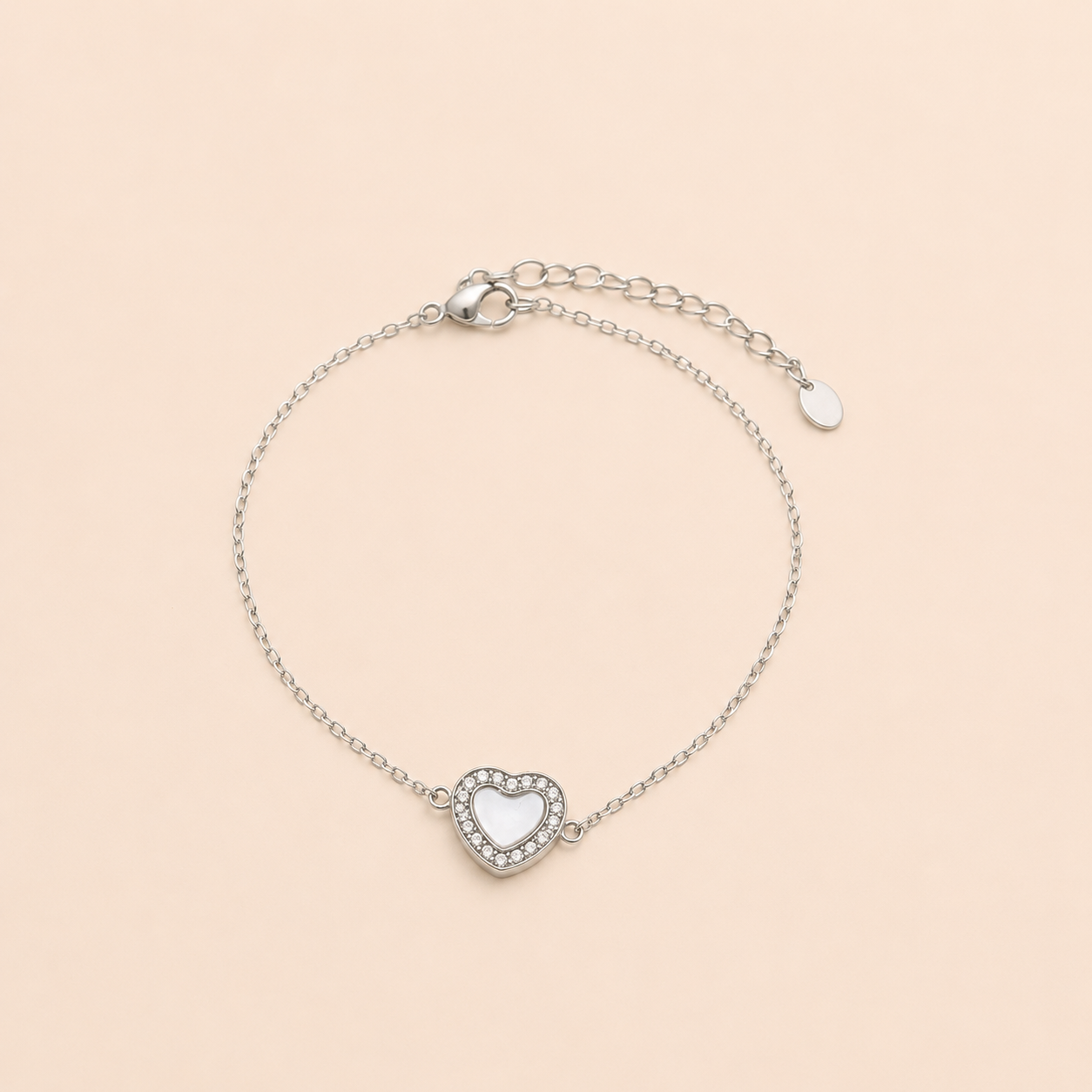 Bracelet Noa argenté avec cœur blanc nacré et zirconiums lumineux sur fond crème minimaliste