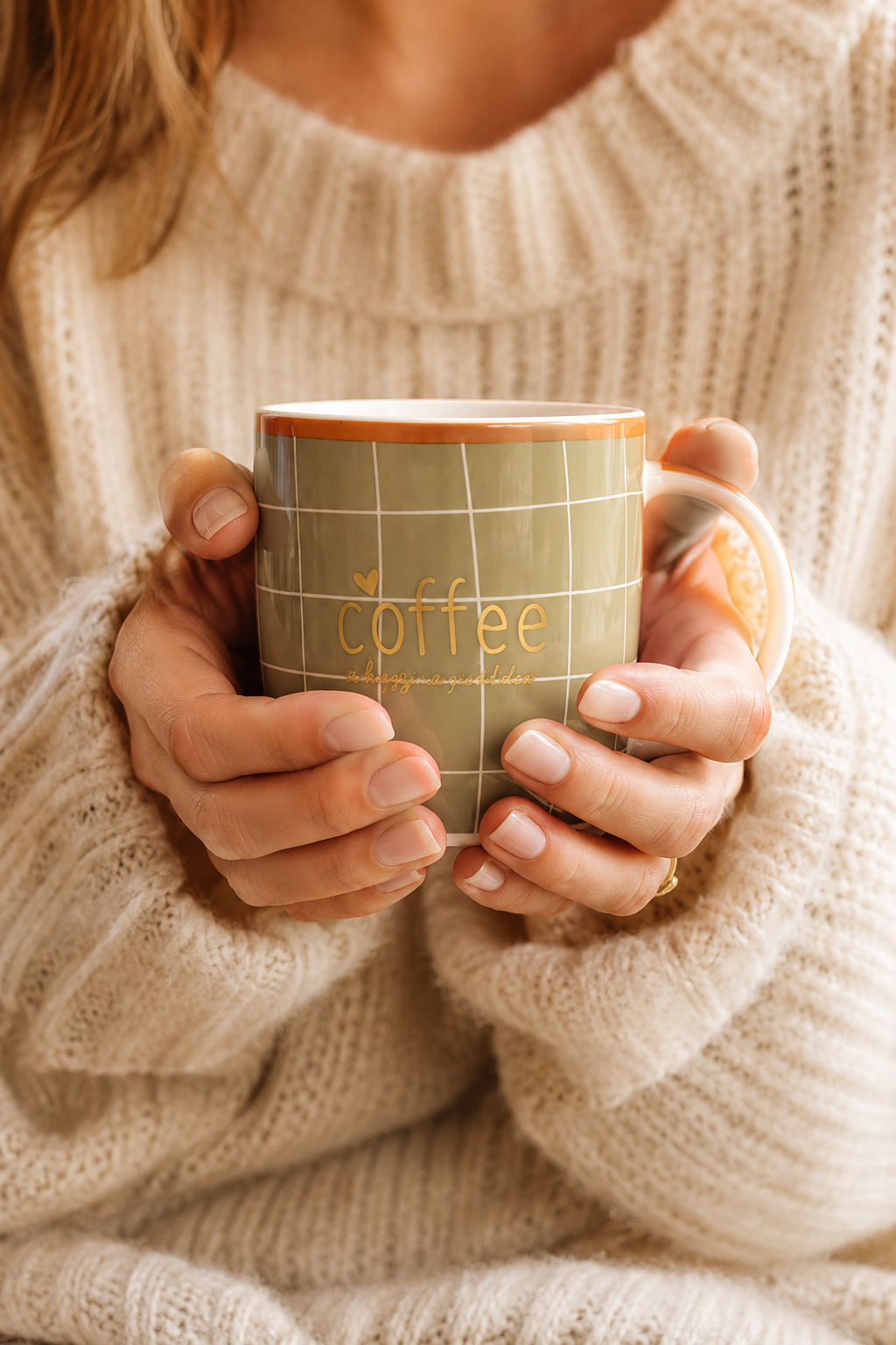Femme tenant un mug en porcelaine kaki quadrillage terracotta dans une ambiance cosy et chaleureuse  ou