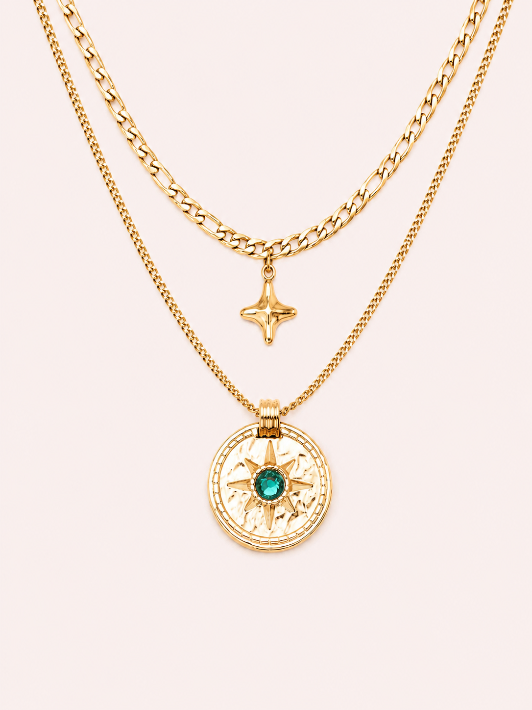 Collier Patti double chaîne dorée avec pendentif astral et pierre verte sur fond rose poudré minimaliste