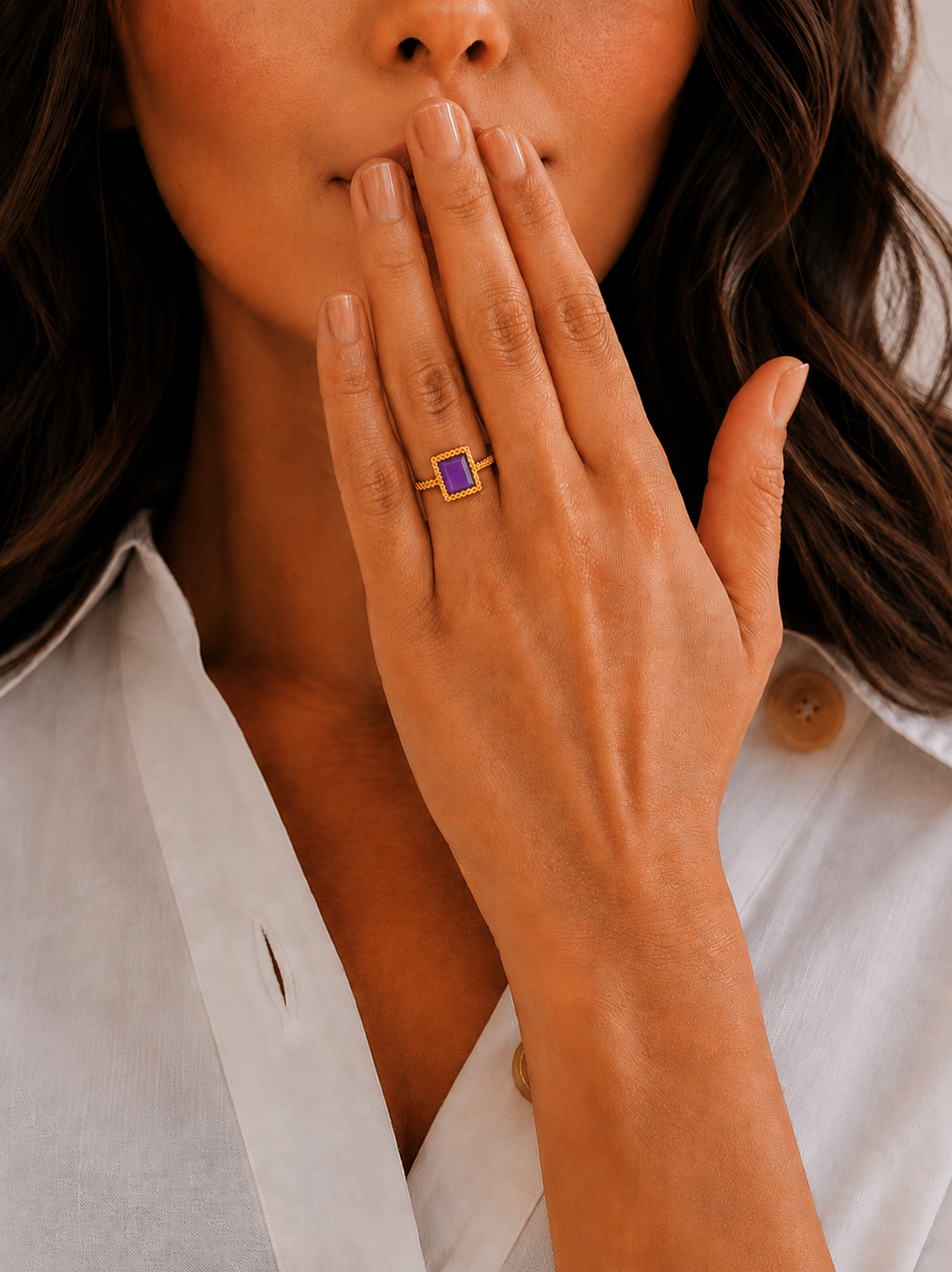 Bague Velina dorée avec pierre violette portée à la main dans un style féminin et élégant