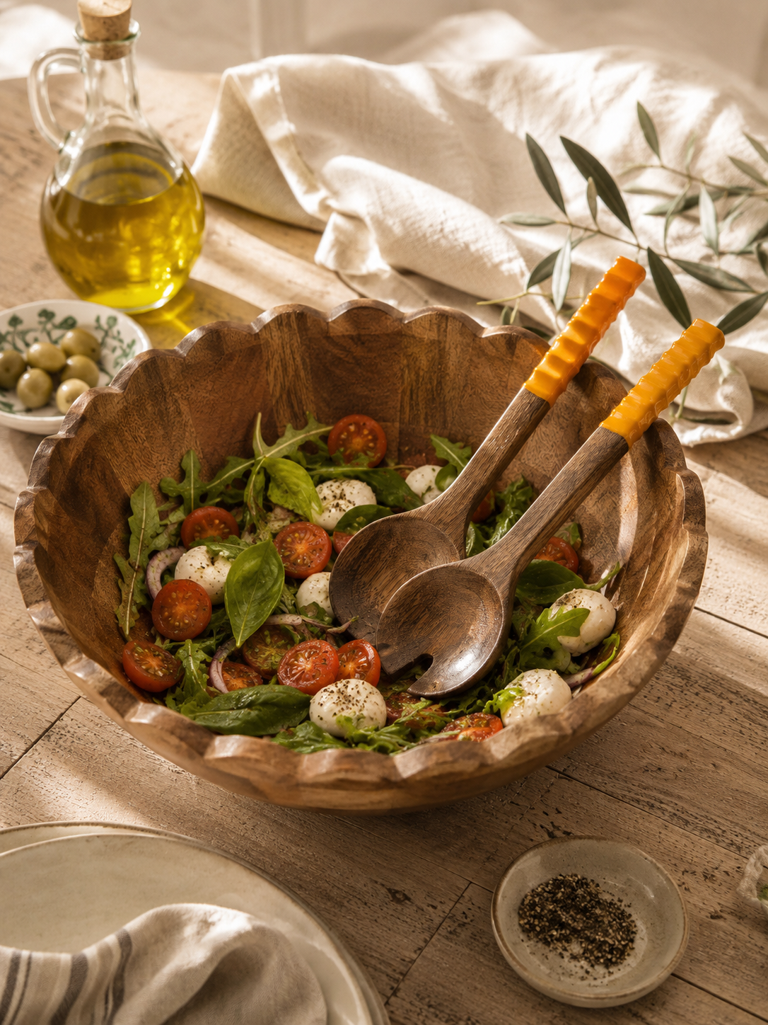 Couverts à salade en bois de manguier assortis au saladier de la collection naturelle Bella Cosa, présentés dans une ambiance de table chaleureuse et conviviale.