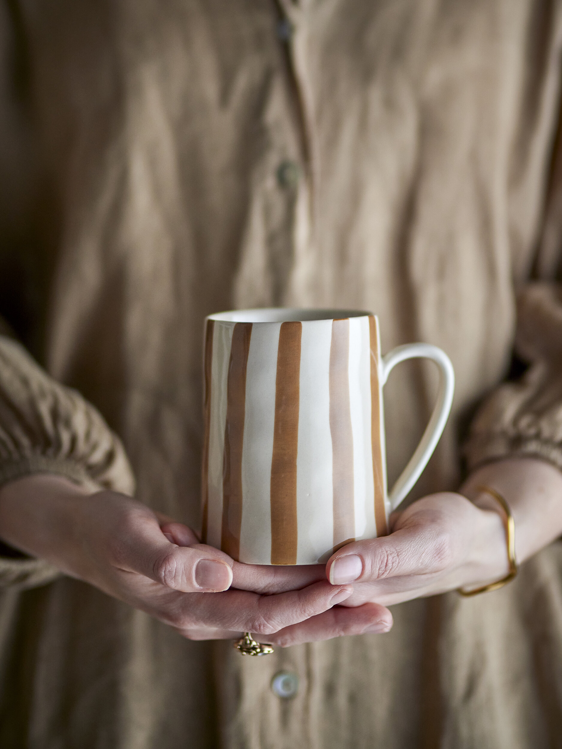Mug Begonia en grès à rayures peintes à la main, tenu dans les mains