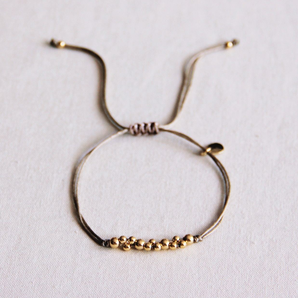 Bracelet Anya en fil de soie taupe avec petites perles dorées