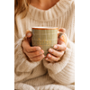 Femme tenant un mug en porcelaine kaki quadrillage terracotta dans une ambiance cosy et chaleureuse  ou