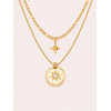 Collier Patti double chaîne dorée avec pendentif astral et pierre blanche sur fond rose poudré minimaliste