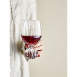 Verre à vin Taurin en verre strié rempli de vin rouge tenue dans la main