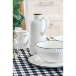Bol en porcelaine blanc avec liseré noir posé sur une table élégante