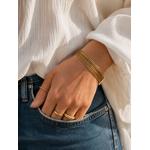 Bracelet Kali porté avec blouse blanche et bijoux dorés dans une ambiance douce et élégante