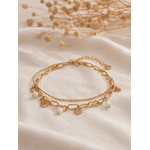 Bracelet Lilo doré double chaîne avec pampilles dorées et petites perles blanches porté dans une ambiance élégante et chaleureuse