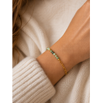Bracelet vert d’eau et or porté au poignet dans une ambiance cosy chic