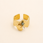 Bague Jodie dorée avec breloques et pierre verte sur fond crème minimaliste – bijou femme élégant Bella Cosa