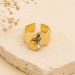 Bague Jodie dorée avec breloques posée sur pierre naturelle beige – bague femme chic Bella Cosa