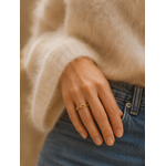 Main portant la bague Opale dorée avec pull beige mohair et jean bleu – bijou femme chaleureux Bella Cosa