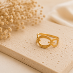 Bague Ohana dorée posée sur pierre naturelle beige avec ambiance chaleureuse et épurée – bague femme Bella Cosa